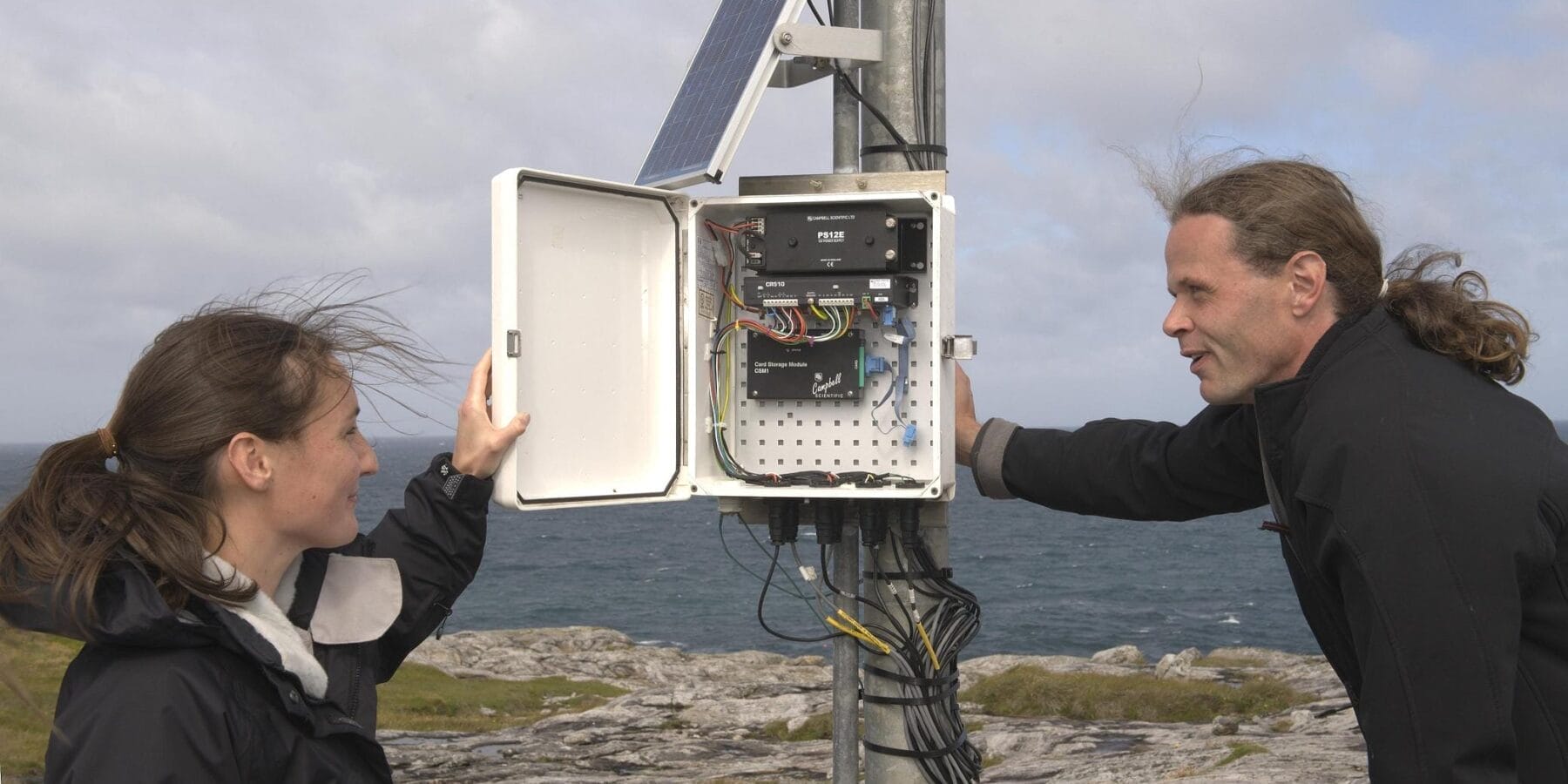Two people looking at wind turbine operations box