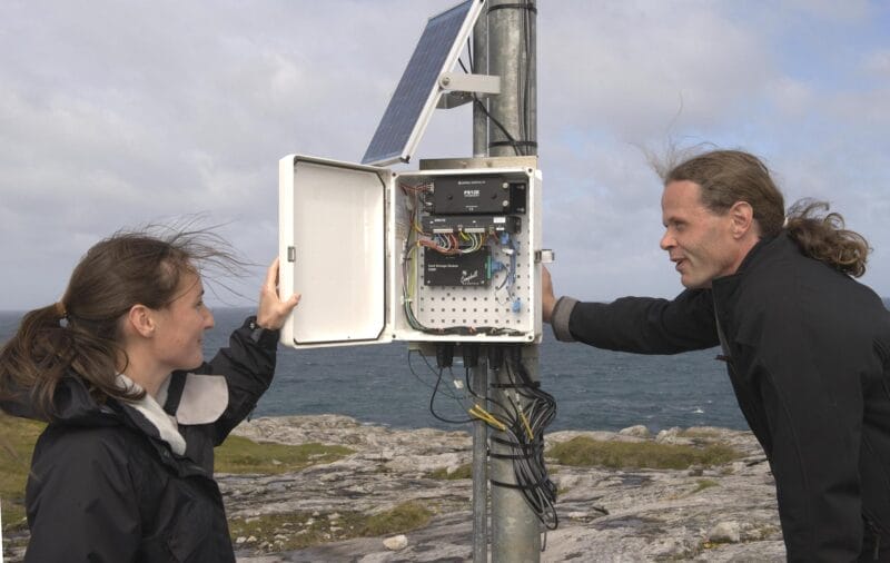 Two people looking at wind turbine operations box