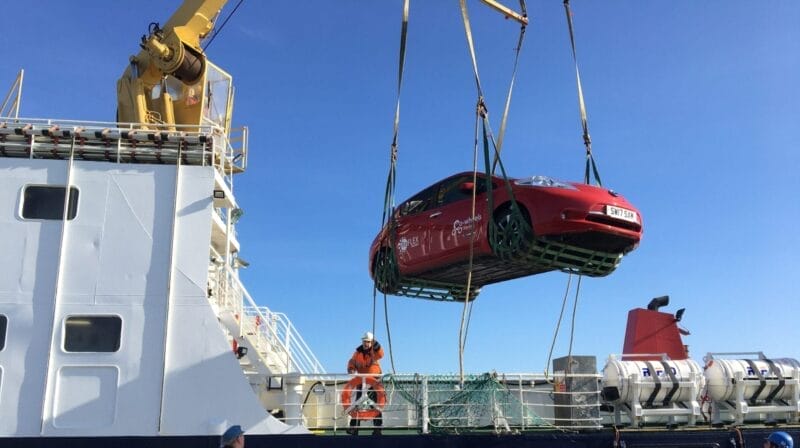 Reflex Car club car being hoisted off ferry in North Ronaldsay, Orkney