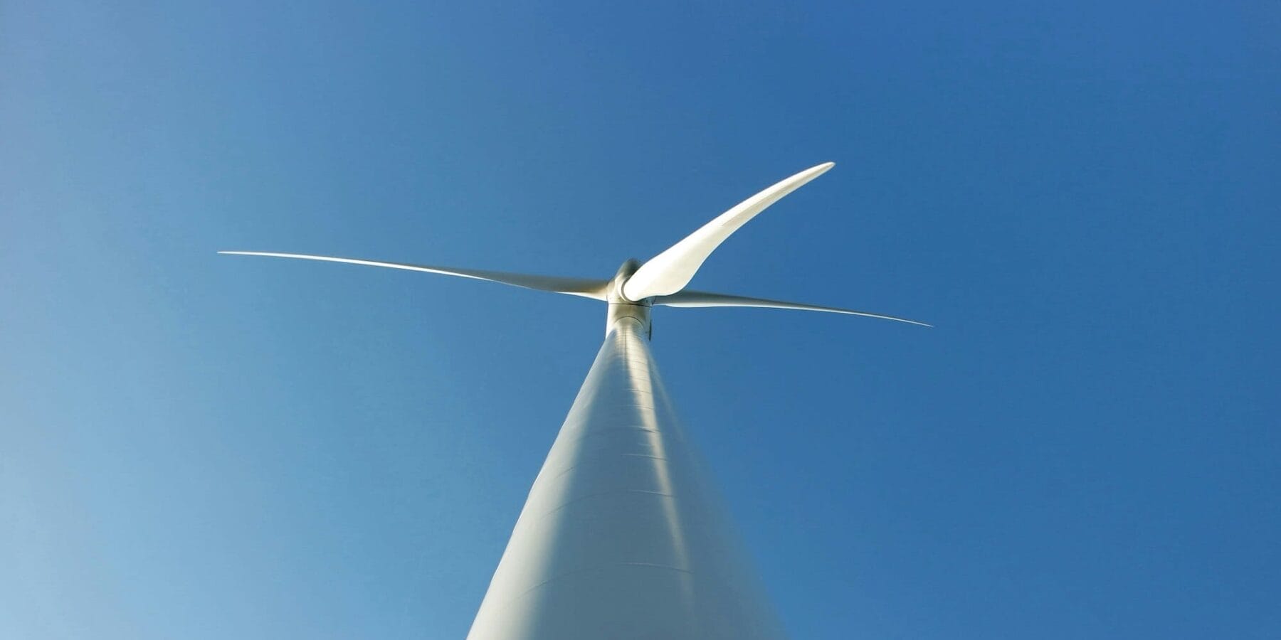 Wind turbine in blue sky - angle from ground