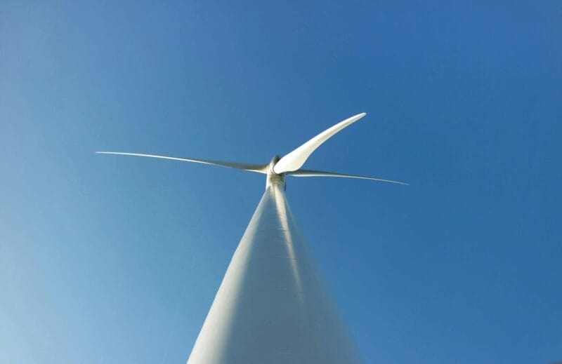 Wind turbine in blue sky - angle from ground