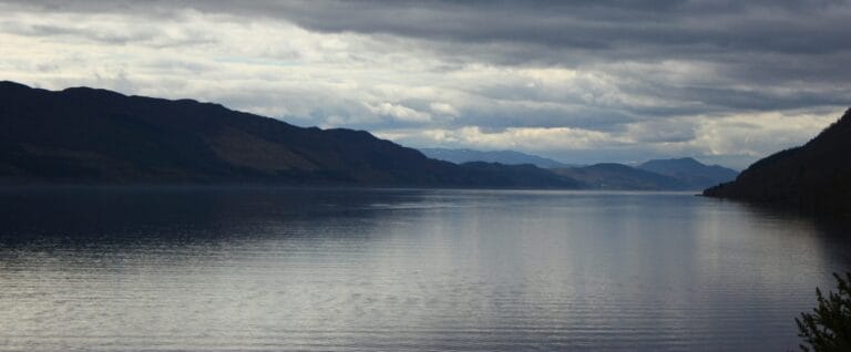 Large loch with hills either side under grey clouds